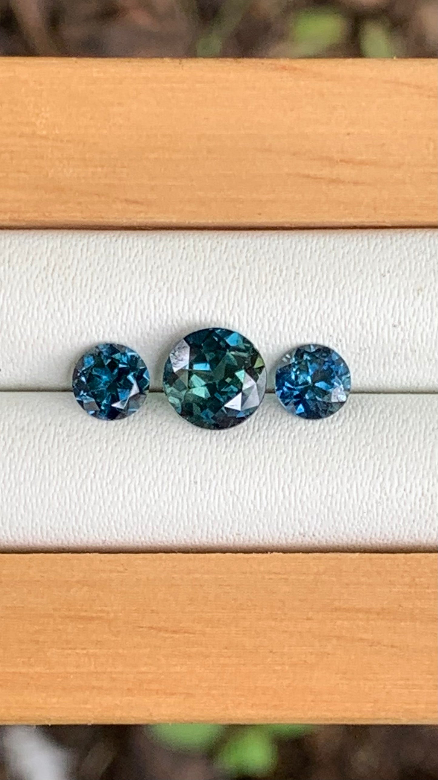 Close up of blue parti centre Australian sapphire trilogy set with blue accents 2.00ct