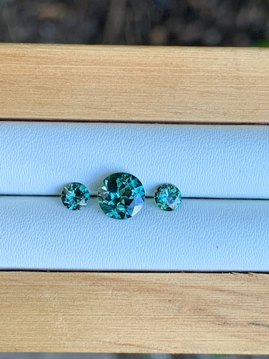 Natural Australian sapphire trilogy set with teal parti centre stone and matched accents