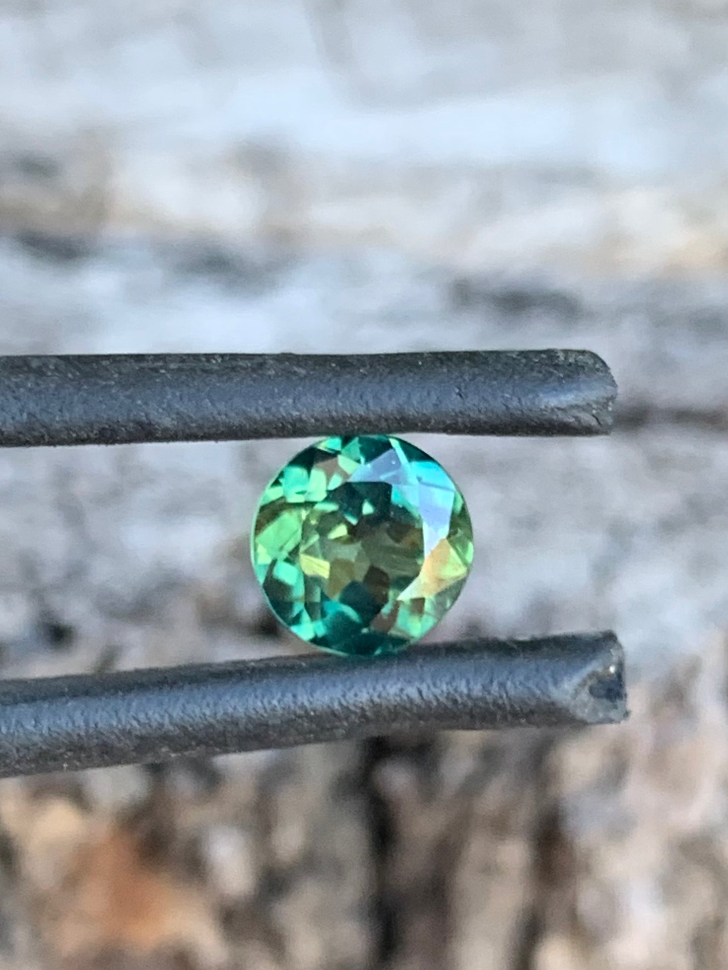 Close-up of 1.03ct teal parti sapphire showing blue and green tones