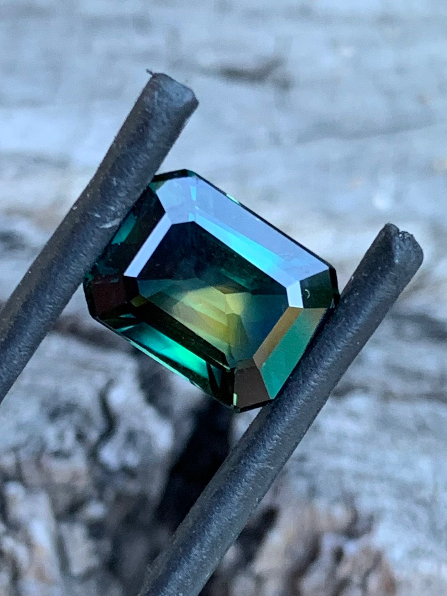 Large emerald cut sapphire with yellow centre and green outer tones