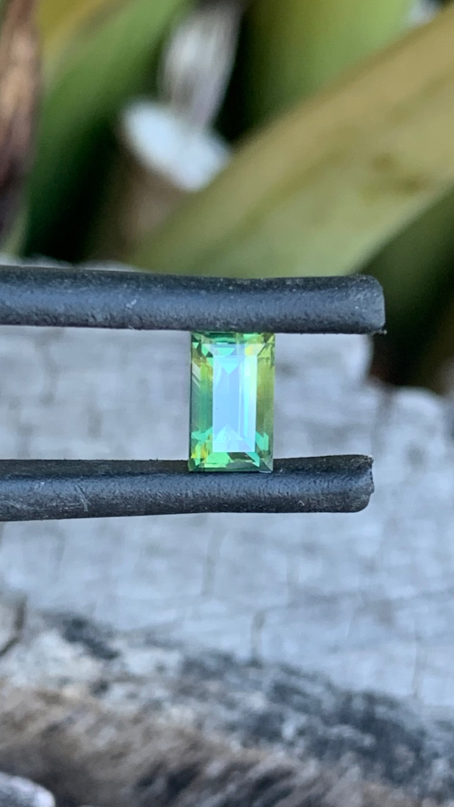 Close up of Light green baguette cut Australian sapphire with yellow zoning