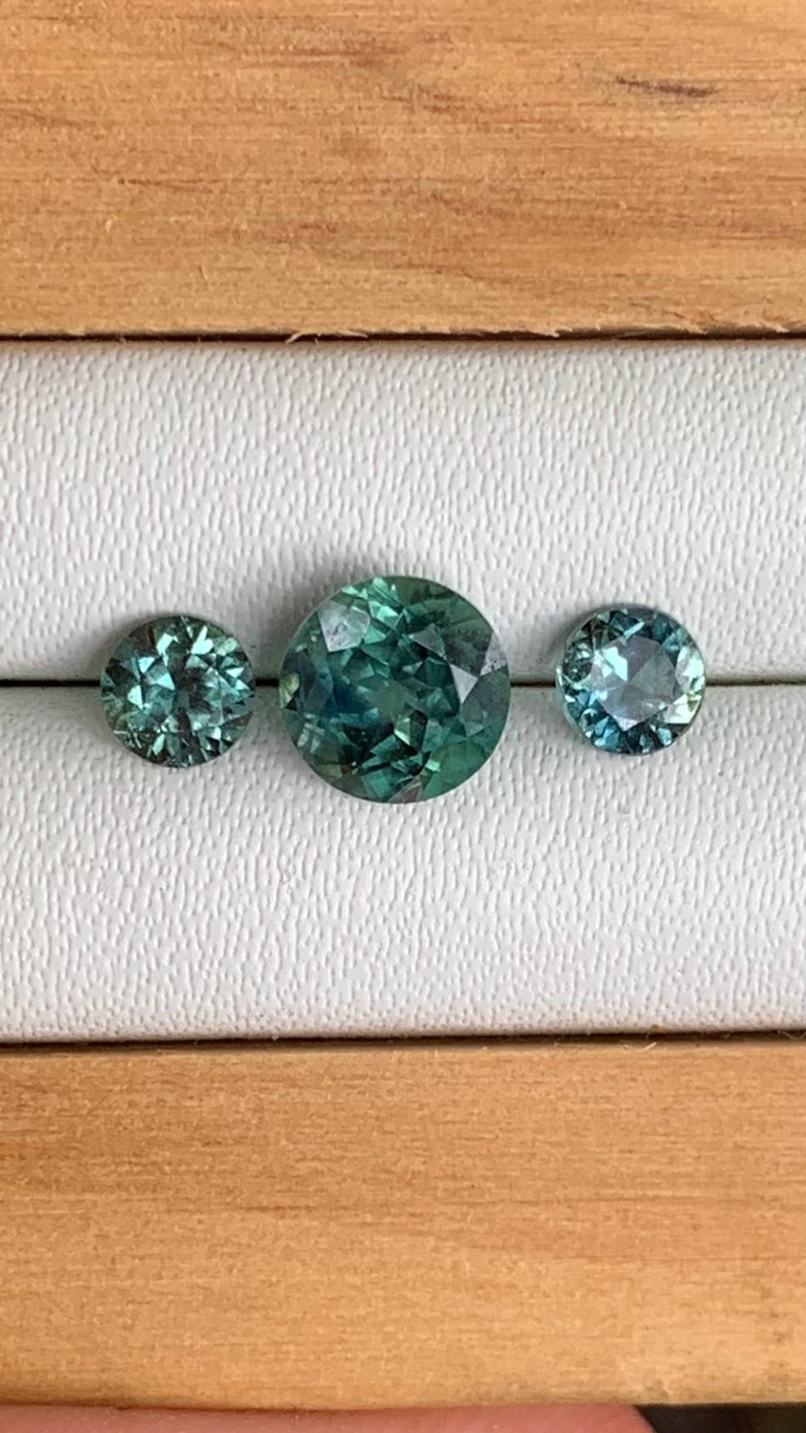 close up teal Australian sapphire centre stone and matching accents