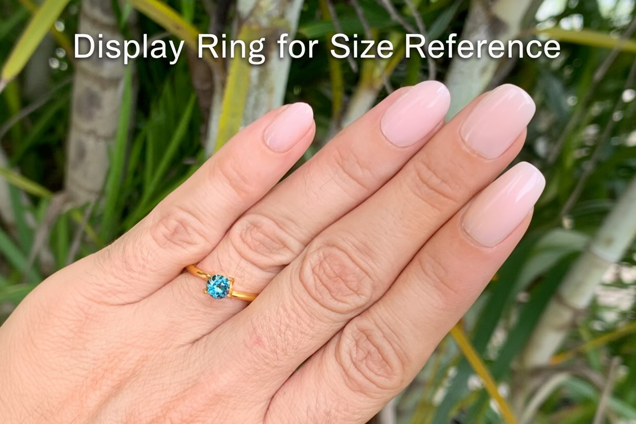 on hand photo of natural Australian sapphire round cut bright blue parti stone 5.37mm