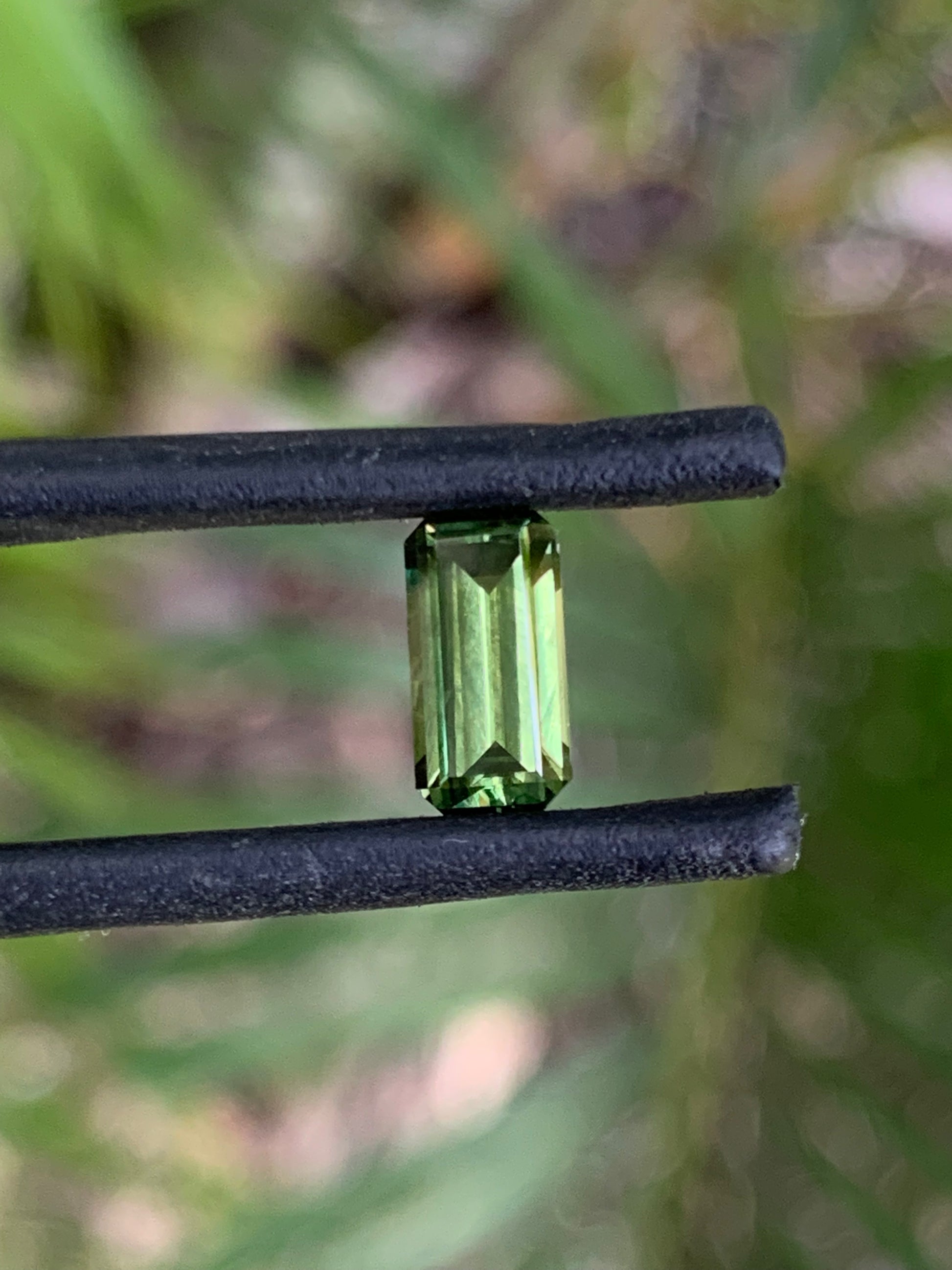 close up elongated emerald cut green sapphire unheated Queensland gemstone