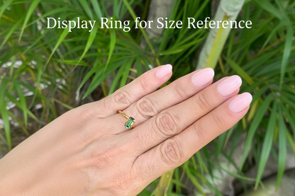 on hand photo of elongated emerald cut green sapphire unheated Queensland gemstone