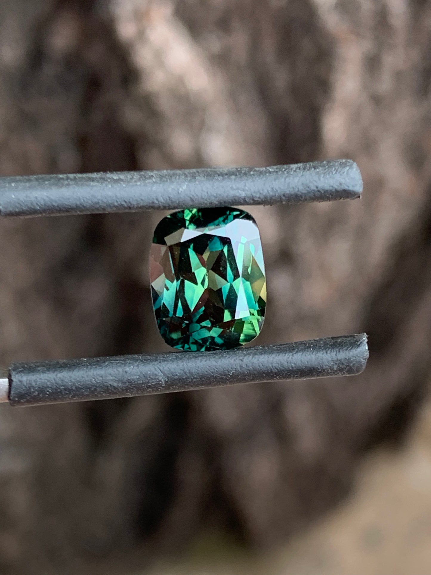 close up teal and yellow parti sapphire unheated Queensland gemstone cushion cut