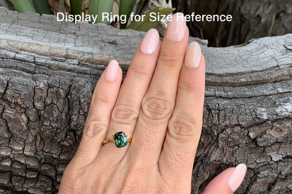 on hand photo of large Australian sapphire cushion cut teal parti with natural colour banding