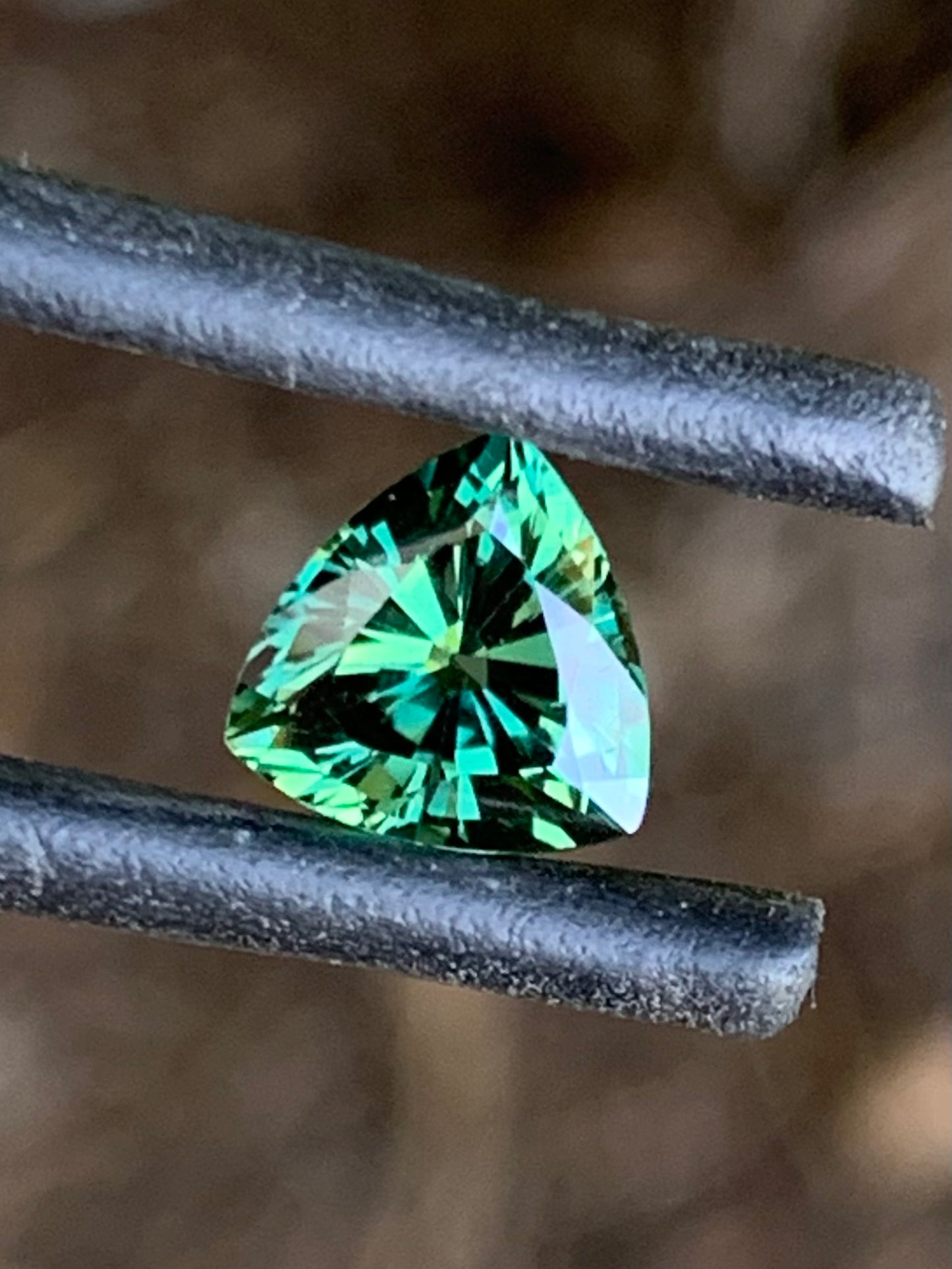 Vibrant green trillion cut Australian sapphire with brilliant sparkle
