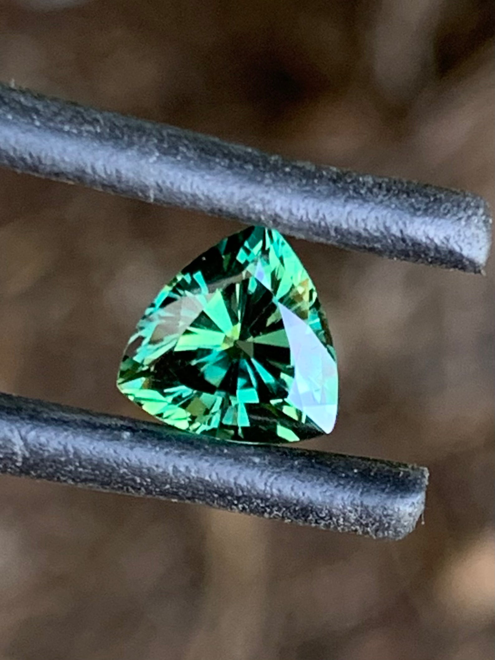 Vibrant green trillion cut Australian sapphire with brilliant sparkle