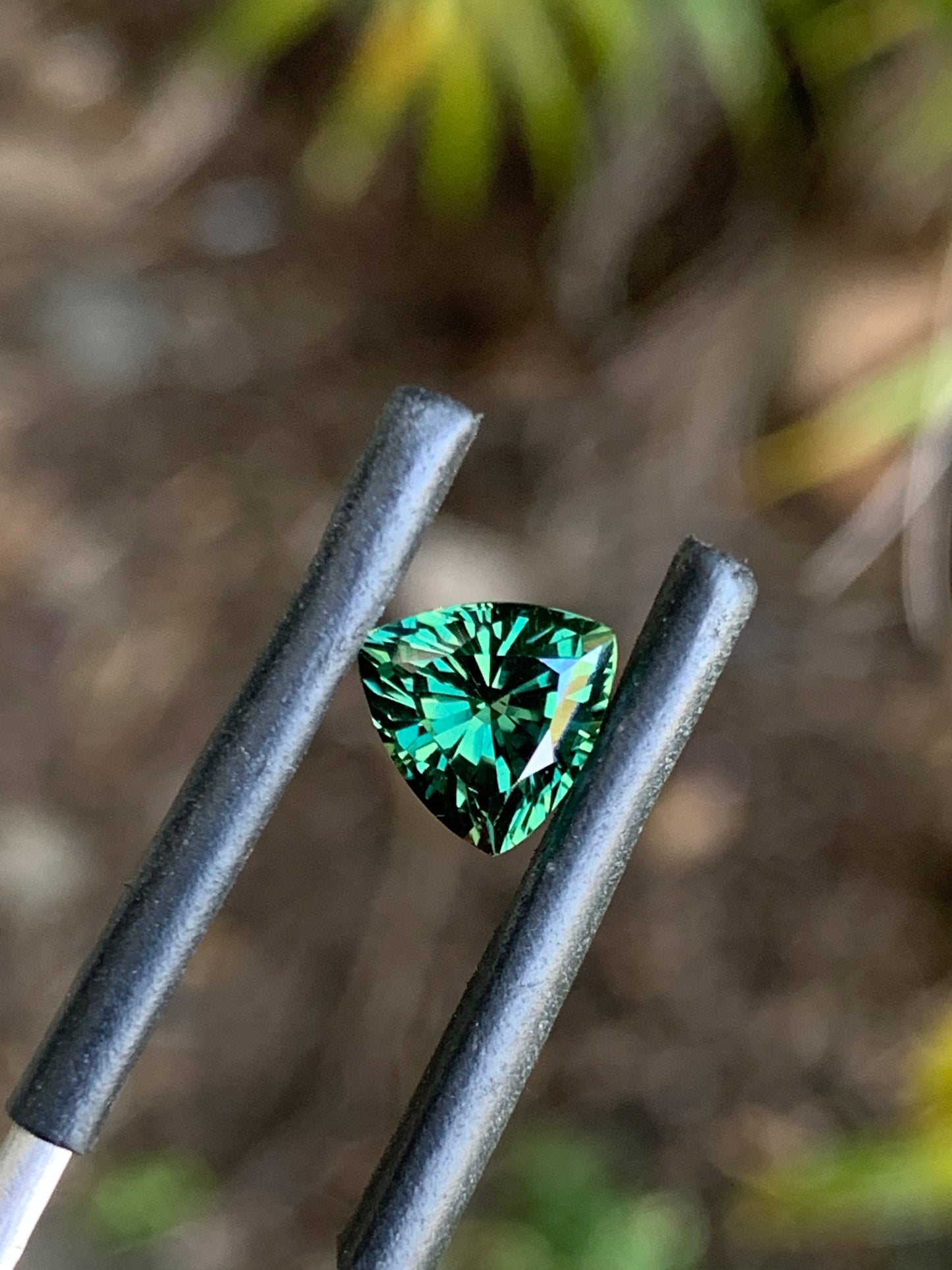 Close-up of a faceted green trillion sapphire from Australia