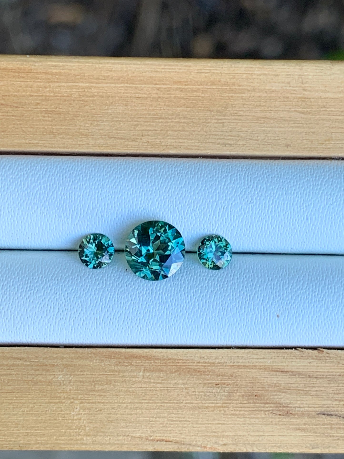 Natural Australian sapphire trilogy set with teal parti centre stone and matched accents