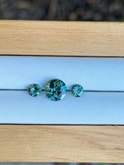 Natural Australian sapphire trilogy set with teal parti centre stone and matched accents