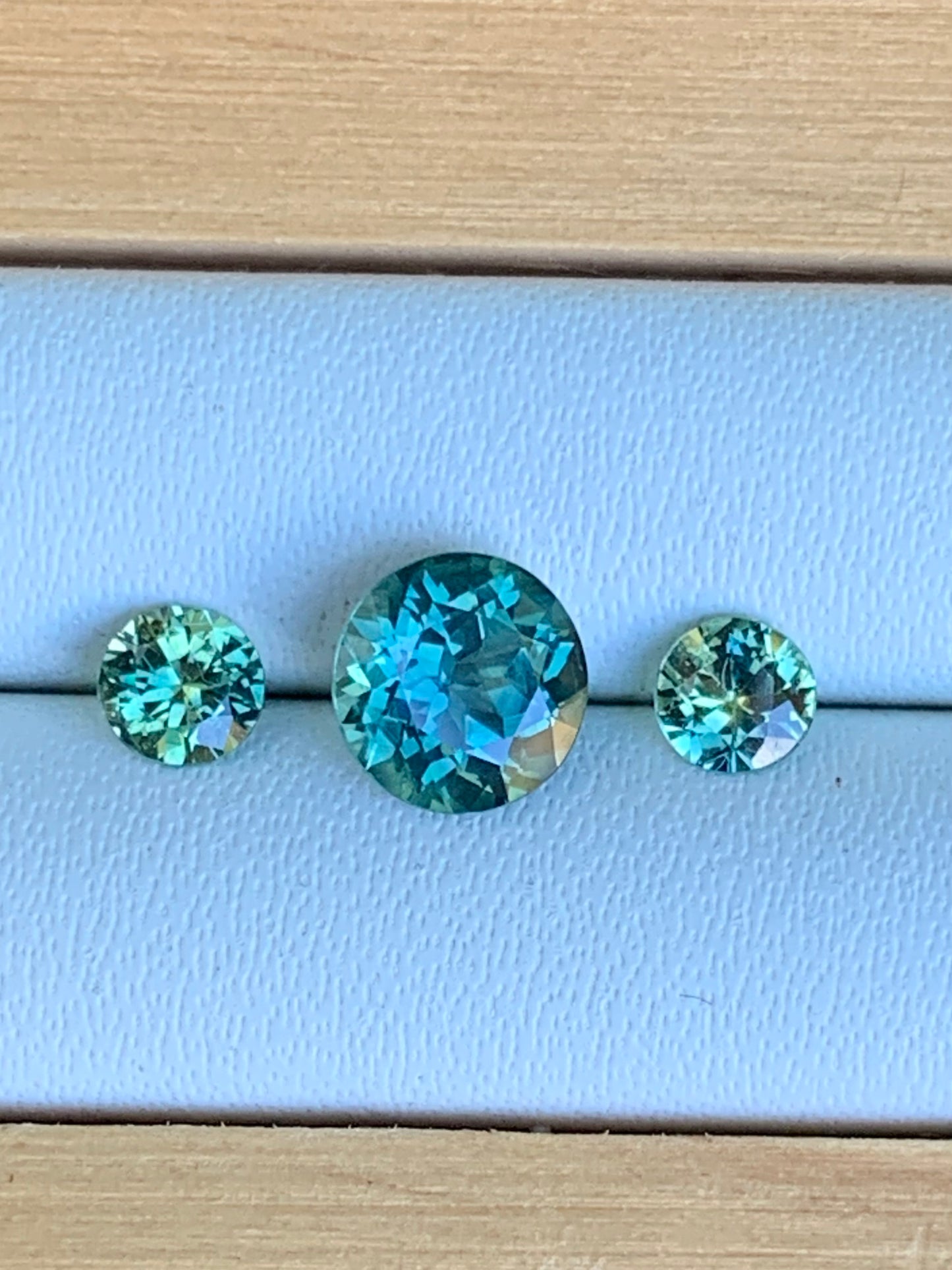 Natural Australian sapphire trilogy set with teal parti centre stone and matched accents