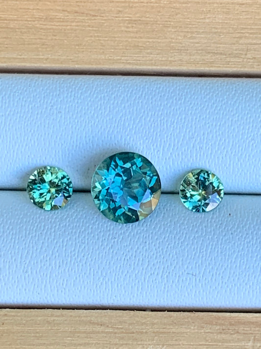 Natural Australian sapphire trilogy set with teal parti centre stone and matched accents