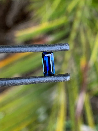 Elongated emerald cut sapphire with vibrant blue colour and natural banding
