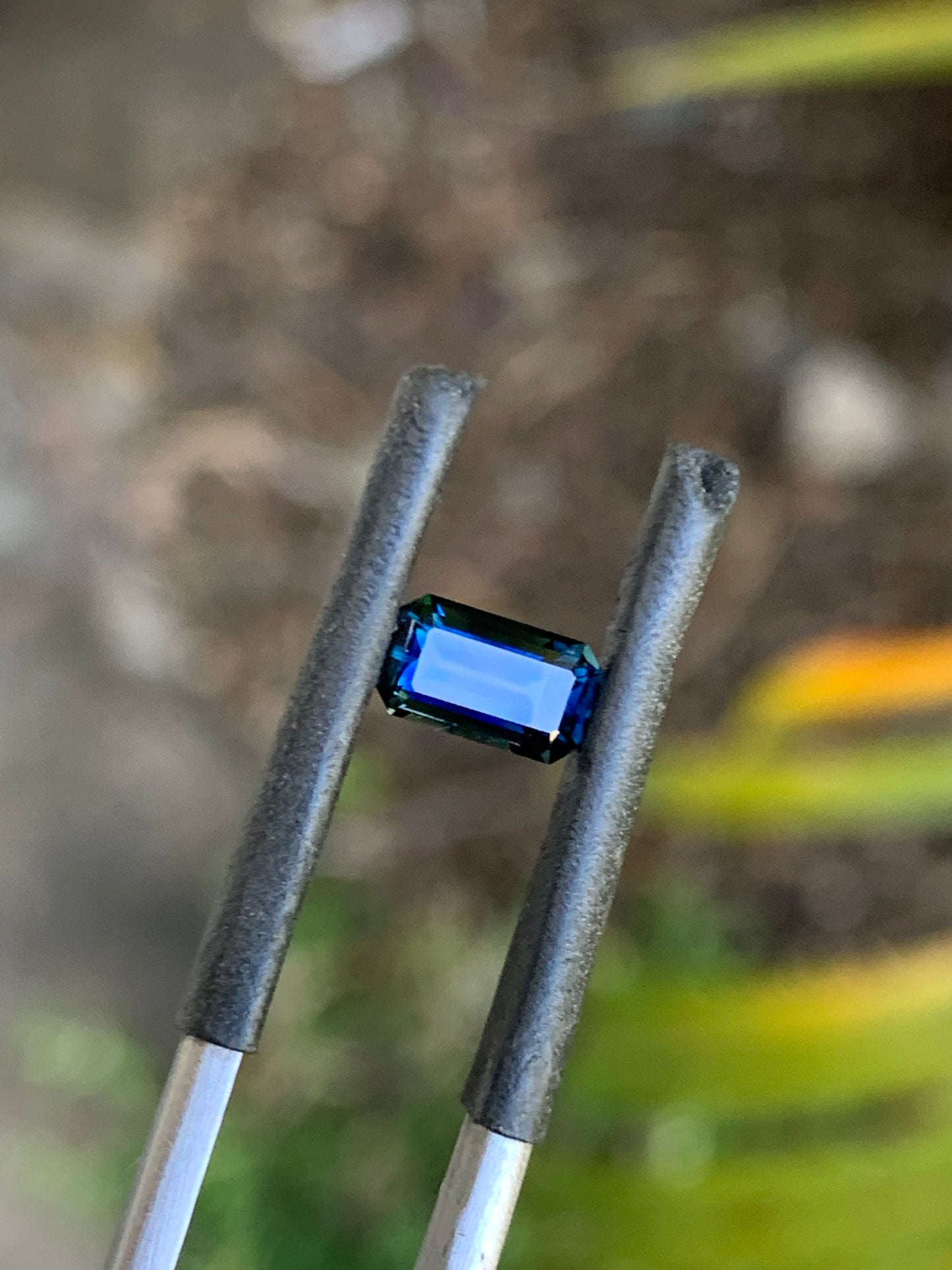 Dark blue emerald cut Australian sapphire with vibrant blue flashes