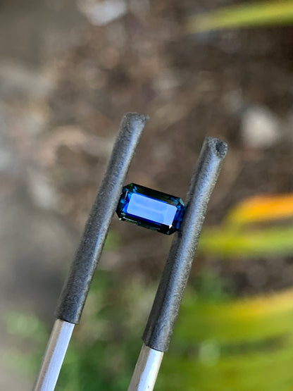 Dark blue emerald cut Australian sapphire with vibrant blue flashes