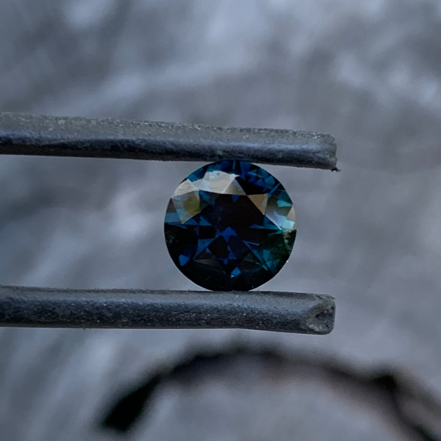 Round cut Australian sapphire showing deep blue colour and vibrant flashes