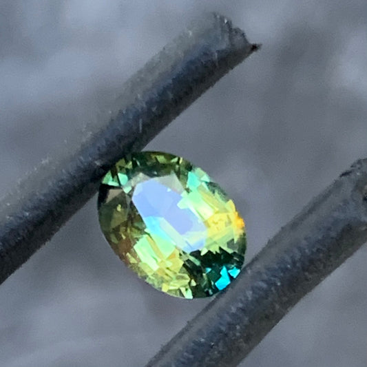 Oval Australian sapphire with soft yellow green colour and blue flashes