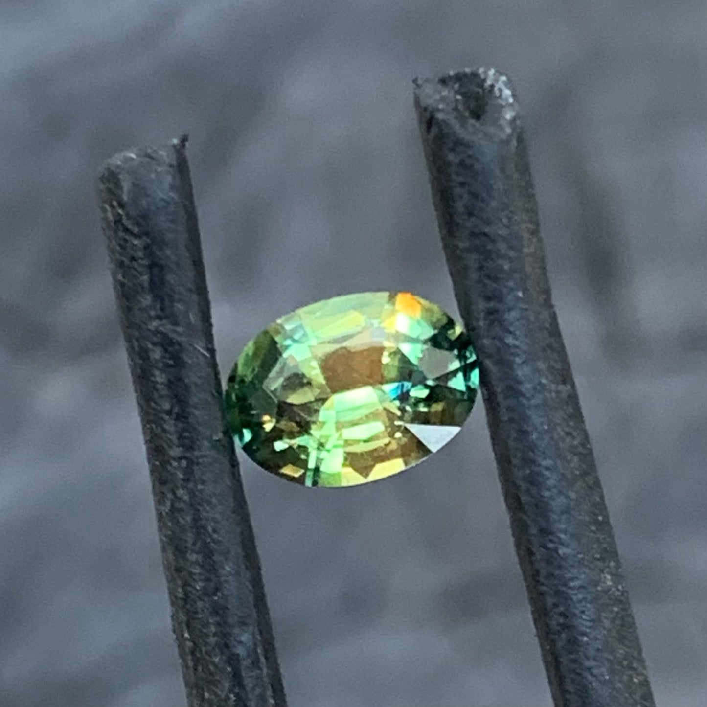 Delicate oval sapphire showing natural yellow, green and blue colour play