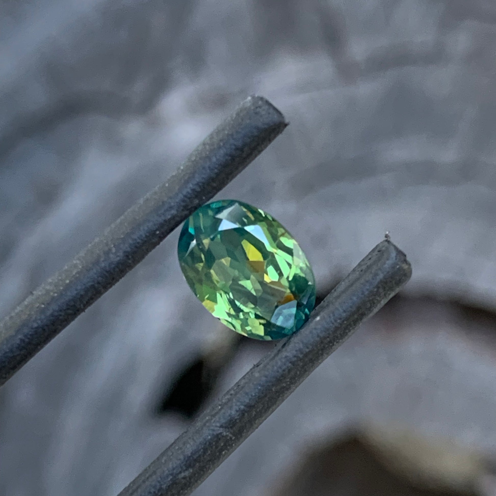 Teal green parti sapphire with natural silk banding and soft glow