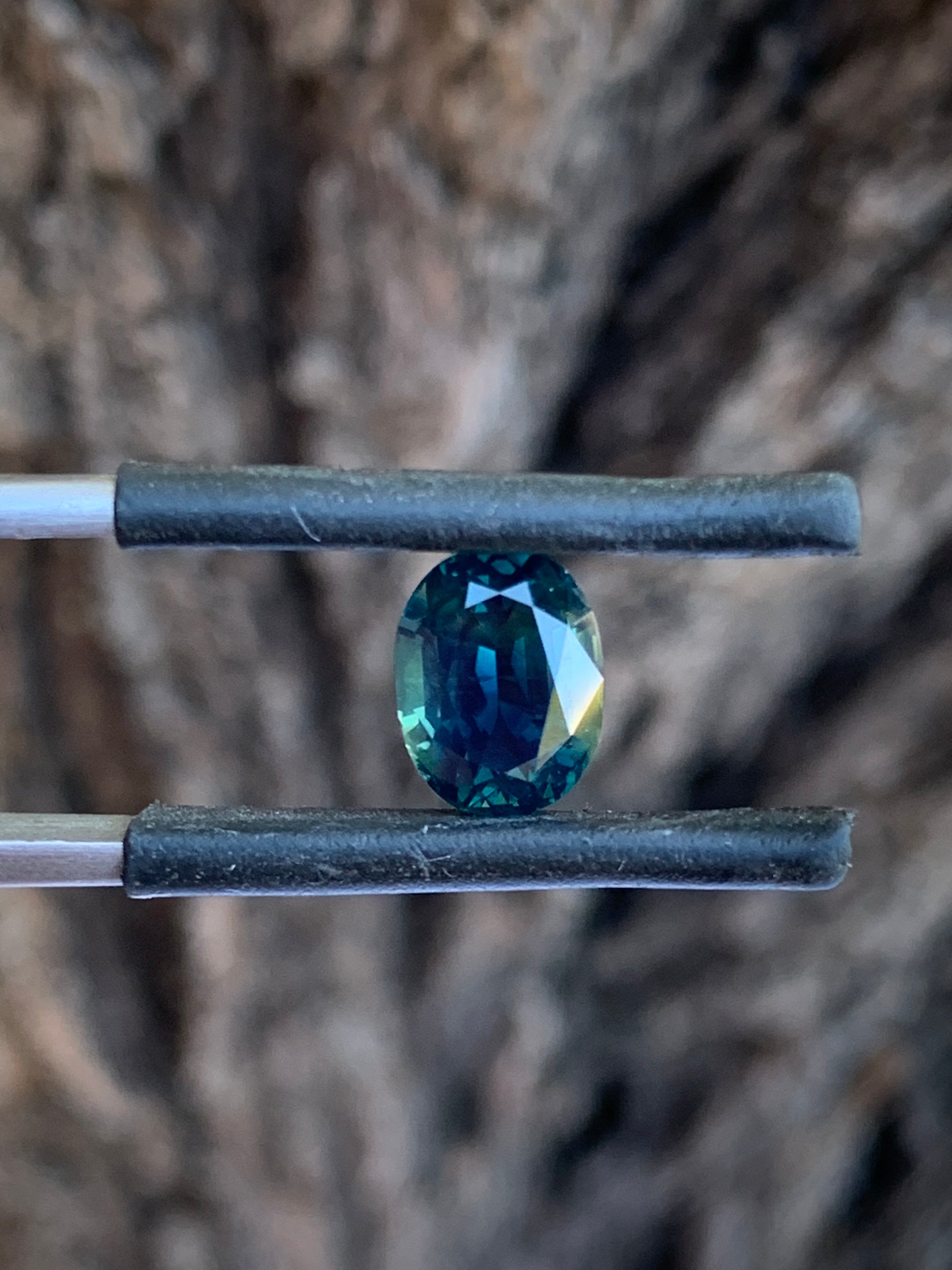 Oval Australian sapphire with deep moody teal parti tones