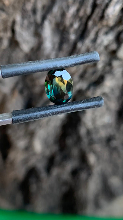 Natural Australian sapphire showing teal blue green and yellow colour in an oval cut