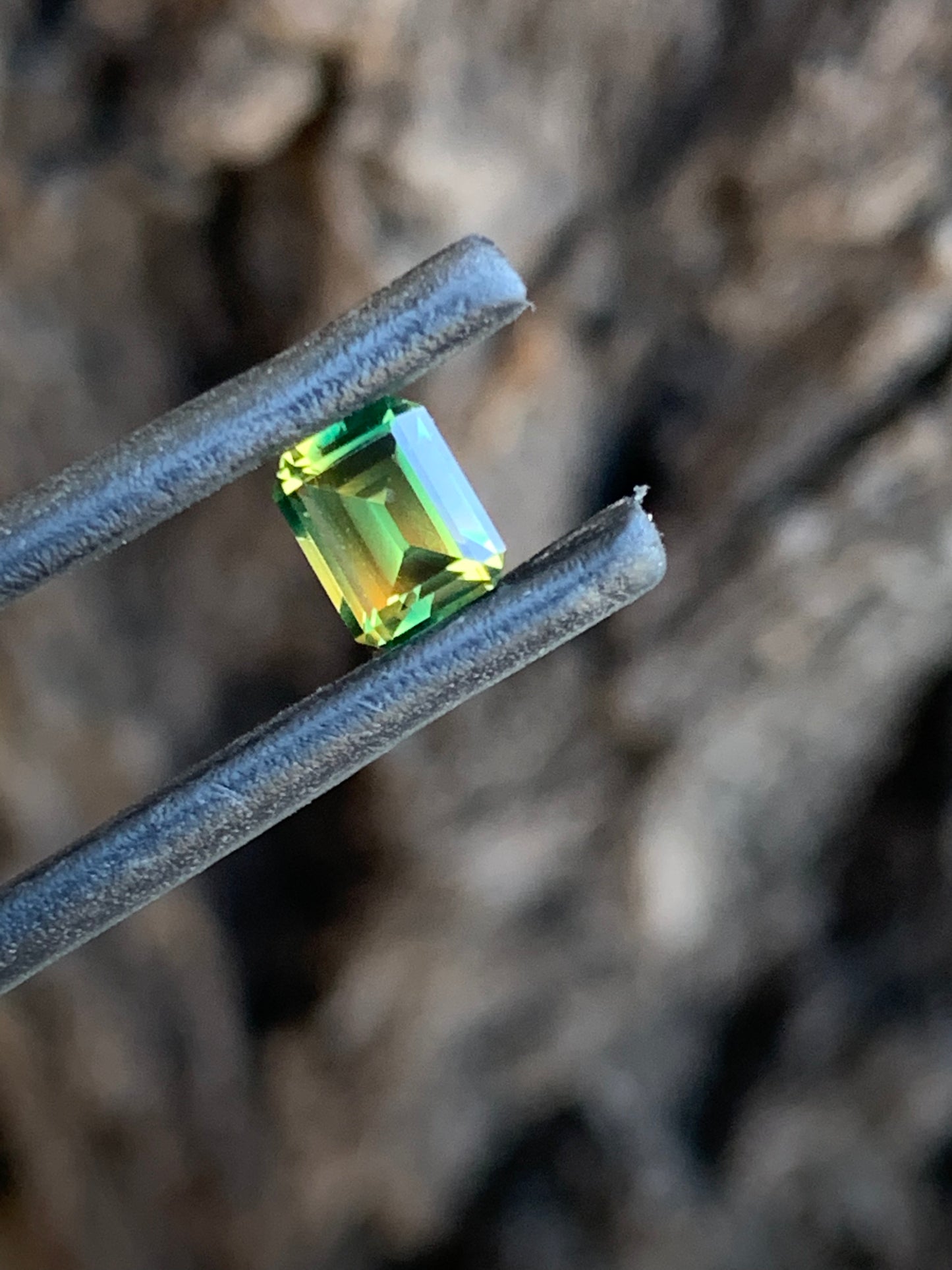 Emerald cut Australian sapphire with incredibly bright yellow green parti colour